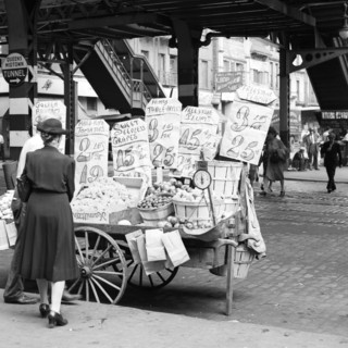 1930s 1940s 59TH STREET THIRD AVENUE UNDER EL STATION WOMAN SHOPPING FOR VEGETABLES AT STREET VENDOR PUSH CART NEW YORK CITY USA - q47436 CPC001 HARS B&W VENDOR CUSTOMER SERVICE CHOICE EXTERIOR AT OPP...