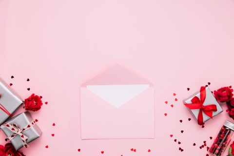 Saint Valentine day card template, greeting, wedding invitation flat lay. Top view on pink background with opened pink envelope with blank sheet message, gray gift boxes decorated with heart confetti