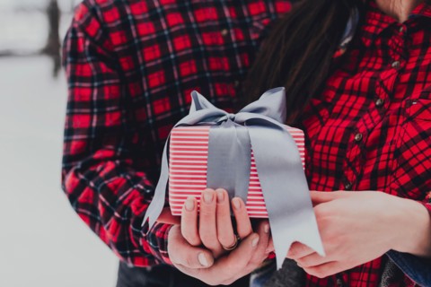 Boyfriend giving a gift box present with ribbon due to Saint Valentine day
