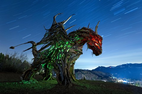 Drago Vaia (Vaia Dragon) in the dead of night. The sculpture is the work of the artist Marco Martalar. Lavarone, Alpe cimbra, Trentino, Italy.