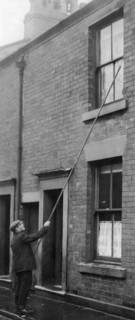 J Thompson the oldest knocker up in Blackburn. The job of a knocker-up's was to rouse sleeping people so they could get to work on time. They used a long and light stick (often bamboo) to tap on the b...