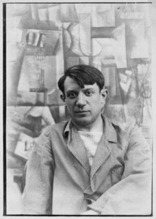 . English: Portrait photograph of Pablo Picasso, in front of his painting The Aficionado (Kunstmuseum Basel) at Villa les Clochettes, Sorgues, France, summer 1912 Français : Pablo Picasso devant la pe...
