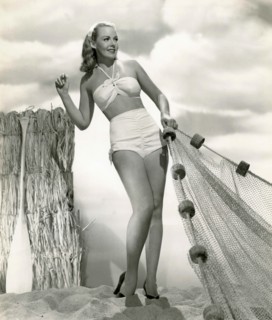 The American actress Angela Green is wearing a white two-piece swimsuit