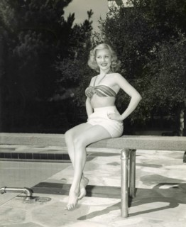 The American actress Lila Leeds with a two piece swimsuit sitting on the trampoline at a swimming pool