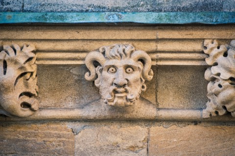 Carved stone horned gargoyle / grotesque on Merton college. Oxford, Oxfordshire, England