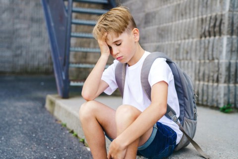 very sad boy bullying in school playground.