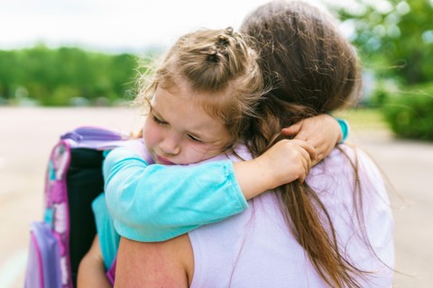 Mother and her daughter to school. Giving a big hug