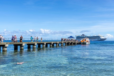 Passengers being transferred to jetty by small tenders from cruise liner anchored off Kiriwina Island, Papua New Guinea