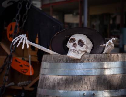 Scary scene of a skeleton looking out of a wine barrel - halloween scene