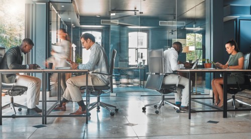 Coworking space, office and sharing desk in corporate workplace. Diversity, efficiency and modern working environment for inclusive company. Start up and motion blur of fast and busy employees