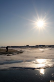 Man walking on melting ice sheet over Lake Michigan