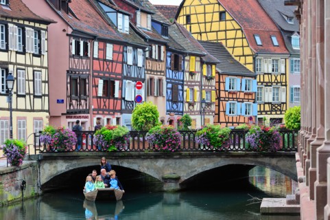Tourists in boat at sightseeing trip along the colorful timber framed houses at Petite Venise / Little Venice, Colmar, France