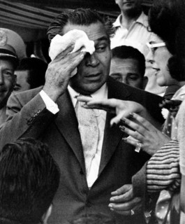 Cuban President Fulgencio Batista wiping his head at a race