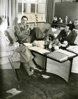 Production conferences begin as Walt Disney downs doughnuts and coffee in his office. With Disney are production manager Harry Teitel (left) and editor Hal Adelquist.