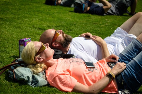 Nashville, Tennessee, USA. 21th August, 2017. A couple rests on the ground looking up at the sky in Centennial Park in Nashville, Tennessee, USA watching the solar eclipse that spanned a 70-mile wide ...