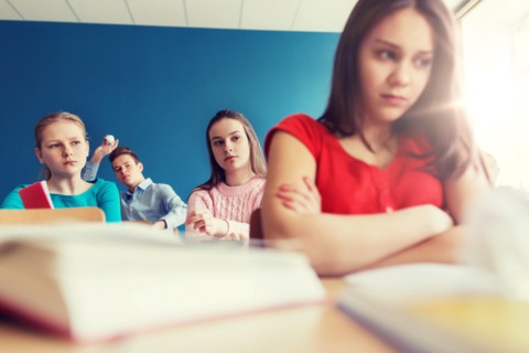 students gossiping behind classmate back at school
