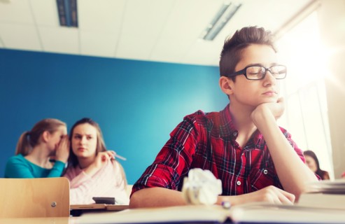 students gossiping behind classmate back at school