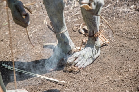 Asaro Mudmen performers making fire, Geremiaka village, Goroka area, Eastern Highlands Province, Papua New Guinea