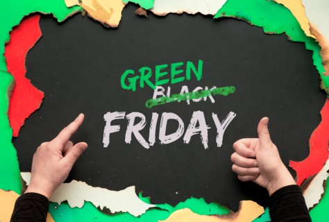 Green Friday, burnt frame with burned color paper. Hands showing OK sign and pointing index finger.Text "Black Friday Sale"  with word "Black" crossed