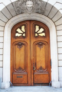 Old fashioned front door entrance, white facade and brown door, Paris, France