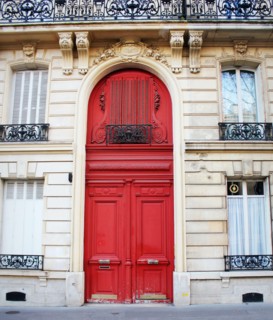 Old fashioned front door entrance, white facade and red door, Paris, France