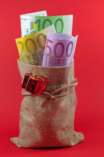 Banknotes, Christmas money in a jute bag against a red background