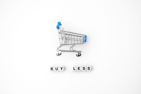 Sustainable consumption and production. Circular economy, Sustainable fashion concept with shopping cart and cubes with text Buy less