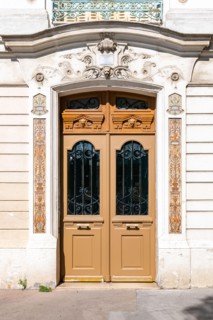Paris, an ancient wooden door, beautiful decorated facade in the 10th arrondissement