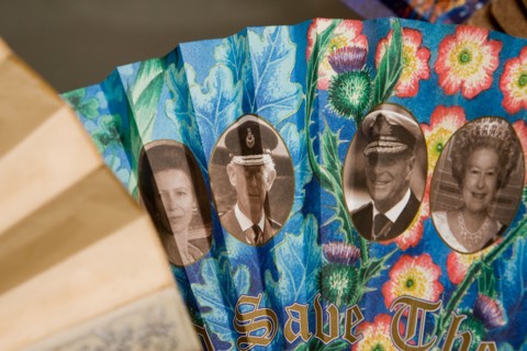 A fan depicting the British Royal Family with the slogan GOD SAVE THE QUEEN printed on it on display at the Fan Museum Greenwich