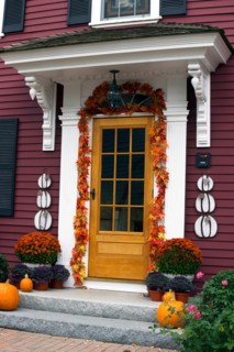 Front door of a traditional clapboard New England house, decorated for Halloween