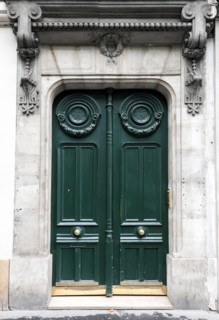 Dark green wooden door in old building facade. Paris, France