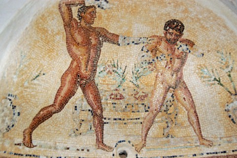 Ancient Roman mosaic showing one man soaping the other.  Arched niche in the baths of the Villa Silene, also known as Villa Celine, in the Khoms area