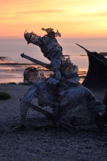 Life size sculptural figure in the D-Day 75 Garden in Arromanches-les-Bains, France at Sunset. The installation was first created by John Everiss for
