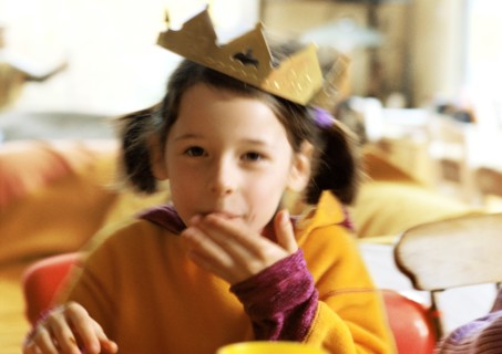 Child with paper crown on head, portrait.