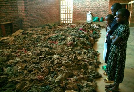 Children standing in a church in rural Rwanda and looking at remains opeople killed during the 1994 genocide