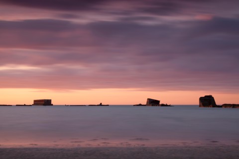 Parts of the remains of the Mulberry Harbour on gold beach Asnelles Calvados Normandy captured at sunset