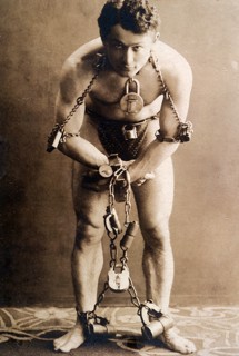 Harry Houdini, full-length portrait, standing, facing front, in chains, circa 1899.  File Reference # 1003_079THA