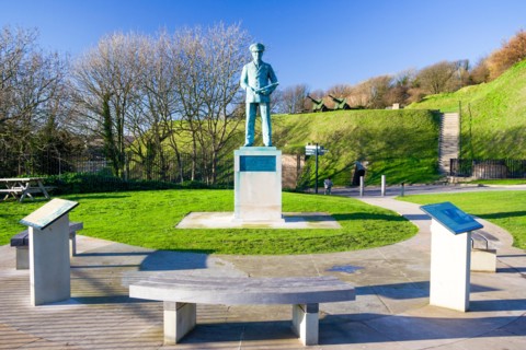 Statue of Vice Admiral Ramsay on the cliff top at Dover castle.Standing with one hand in pocket and the other holding a telescope. Wintertime. Blue sk