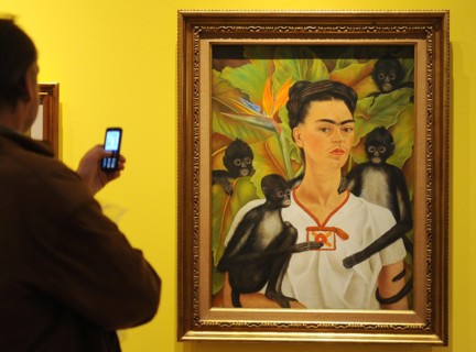 A visitor takes a picture of the painting 'Portrait with Apes' by Frida Kahlo in a retrospective in the Martin-Gropius-Bau in Berlin, Germany, 29 April 2010. The largest exhibition ever about Mexican ...