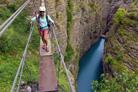 man on narrow rope bridge, via ferrata du Barrage du Sautet, France, Isere