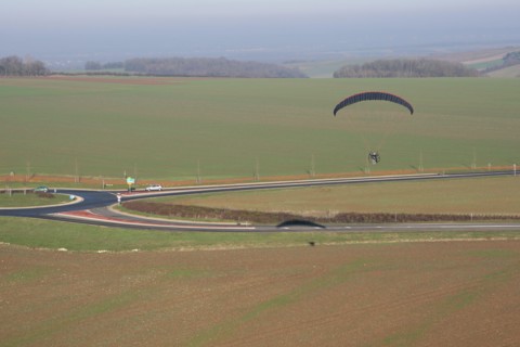 Aerial photograph of a paramotor (motorized paraglider) flying over a roundabout in soindres fields, Yvelines department (78200), Ile-de-France region
