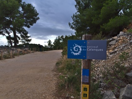 Blue signpost at the entrance of Calanques National Park (Parc National des Calanques) near Cassis at the French Riviera. Focus on sign.