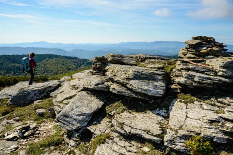 Walker at the summit of Signal de Bougès on the Robert Louis Stevenson Trail in the Cévennes, Lozère, France