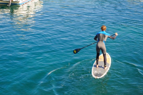 Man paddle boarding, Paddleboarding, out of old port of Biarritz, France.