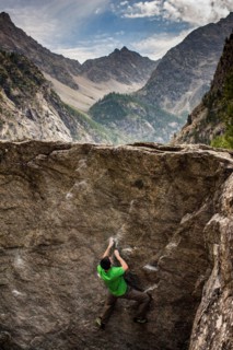 Young man climbs boulders in the Alfroide valley, French Alps