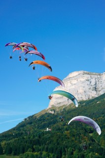 Fleet of nine paramotors flying at the 2017 Coupe Icare event, Dent de Crolles (2062m asl) in the background. Saint-Hilaire du Touvet, Isère, France.