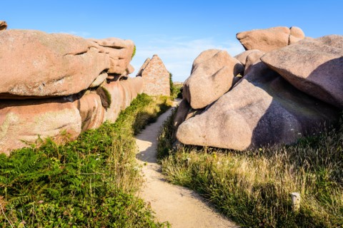 Ruins of a former gunpowder store on the GR34 coastal path in the granite blockfield of Ploumanac'h on the Pink Granite Coast in Brittany, France.