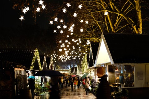 German Christmas market at night  with market stalls and illuminated stars
