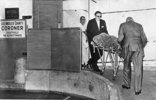1962 , 6 august , LOS ANGELES , USA : The body of american actress MARILYN MONROE ( 1926 - 1962 ) wrapped in blankets , is wheeled from the Los Angeles County Morgue and en route to the Westwood Villa...