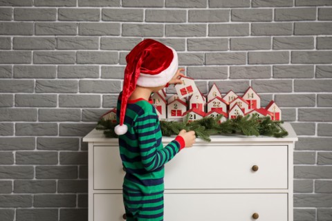 Little boy with Christmas advent calendar at home